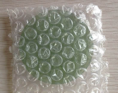 Trois disques de verre dans des sacs à bulles en plastique.