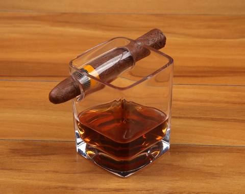 Some wine and a cigar are contained in a cigar whisky glass cup.
