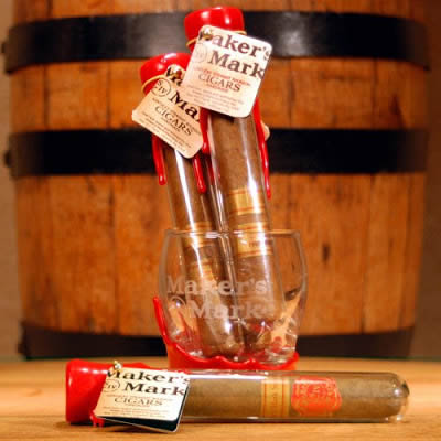 Two cigar glass tubes in a cup and one lying on the table with decorations on the bottleneck.