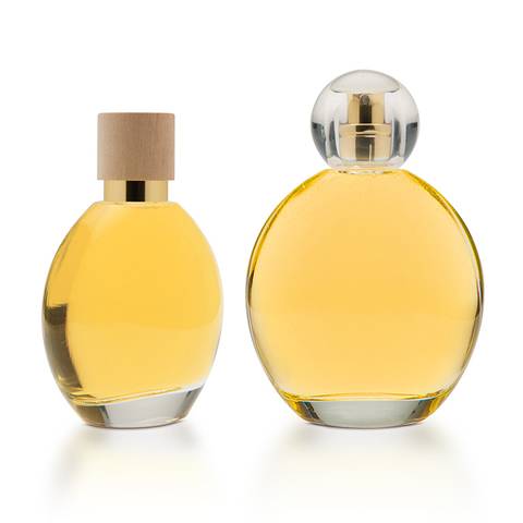 Dos botellas de vidrio llenas de perfume se muestran en el fondo blanco.