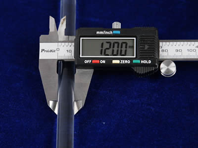 A hand is measuring rod diameter of glass rod with digital vernier caliper.