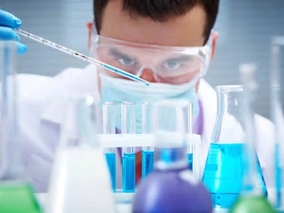 A man is dripping the liquid into the laboratory culture tube.