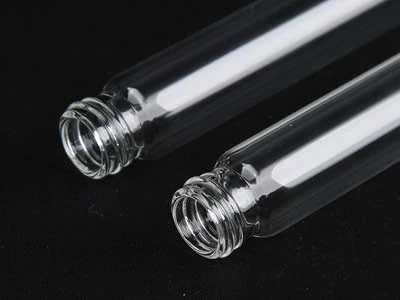 Two laboratory culture tubes with screw top on the black background.