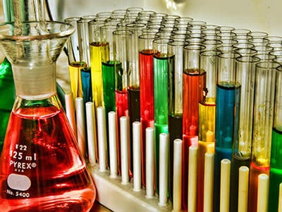 Several laboratory culture tube with different solvents on the test tube racks.