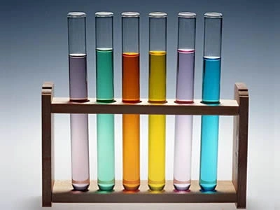 Six laboratory culture tubes with different solutions on the test tube rack.