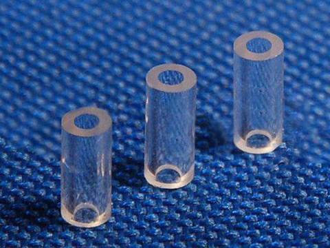 Three round micro capillary tubes with a cavity inserted in each on a blue background.